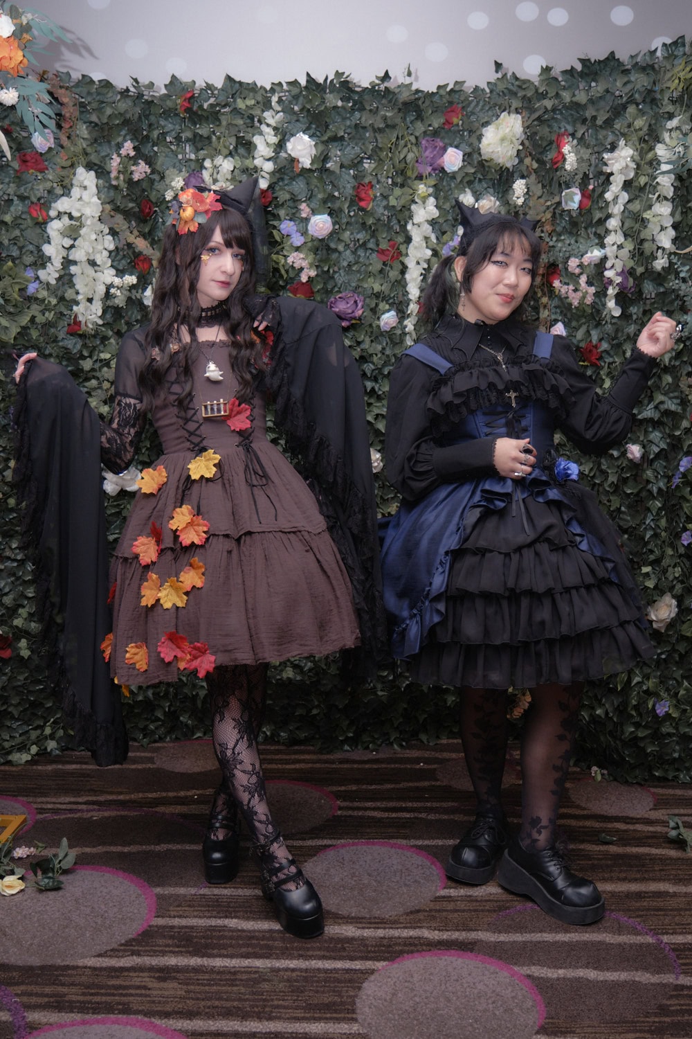 Two gothic lolitas standing next to each other.