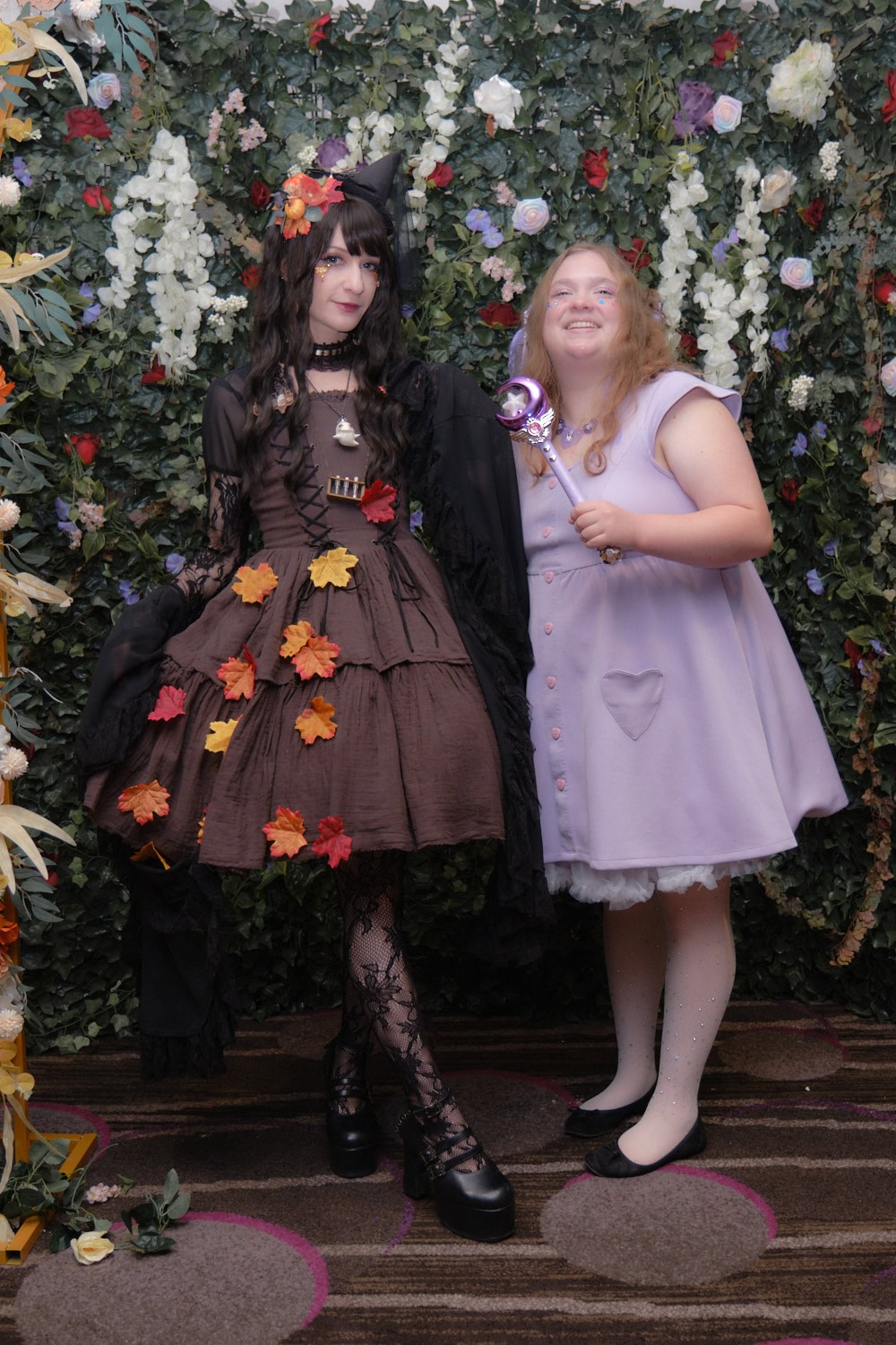 Gothic lolita standing on left next to kawaii woman wearing lavender.