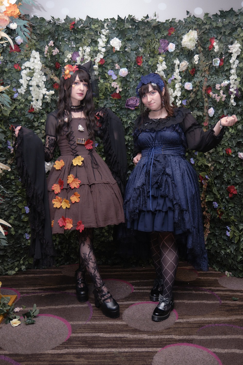 Two gothic lolitas standing next to each other.