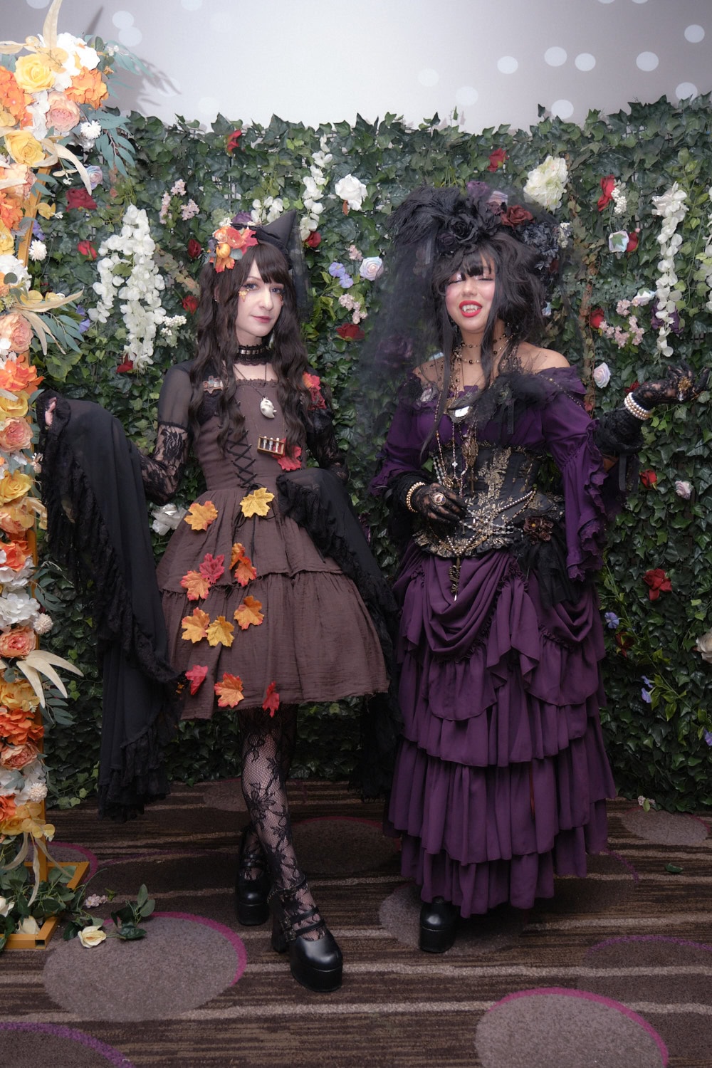 Two gothic lolitas standing next to each other.