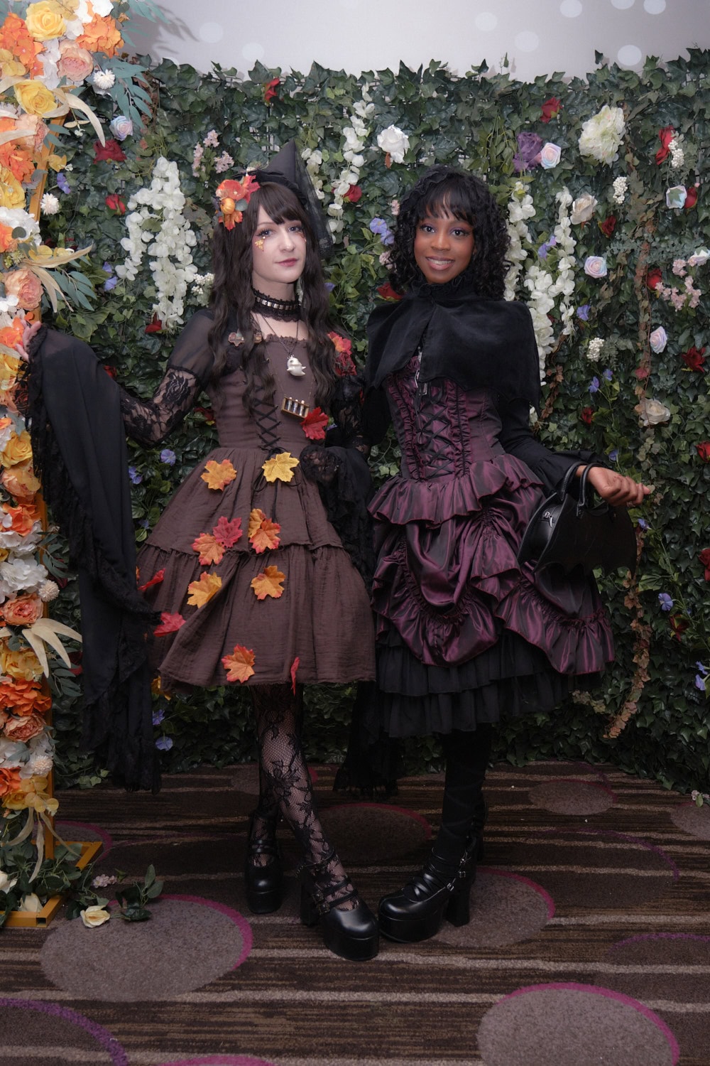 Two gothic lolitas standing next to each other.