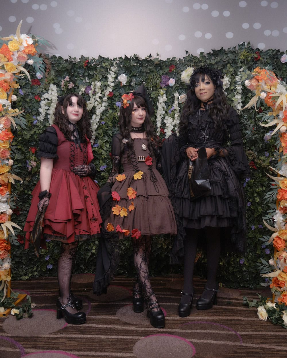 Three gothic lolitas standing together.