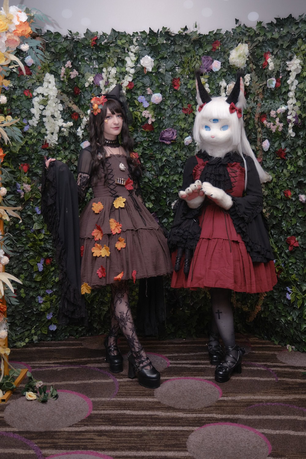 Two gothic lolitas standing next to each other.
