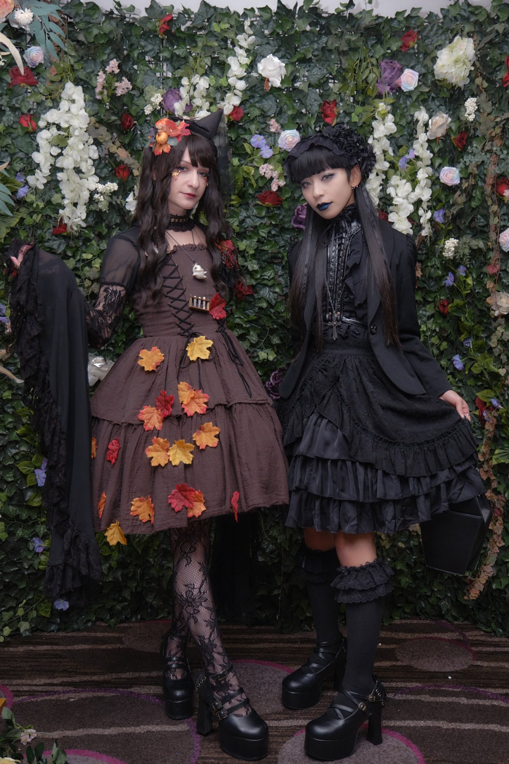 Two gothic lolitas standing next to each other.