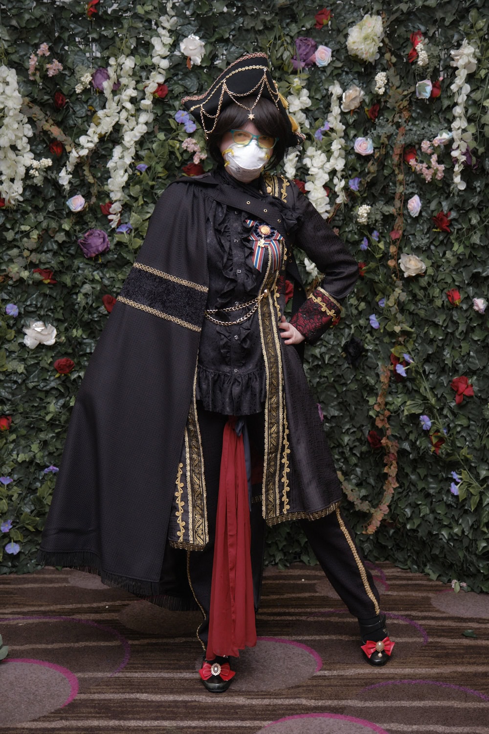 Pirate ouji standing against floral backdrop.