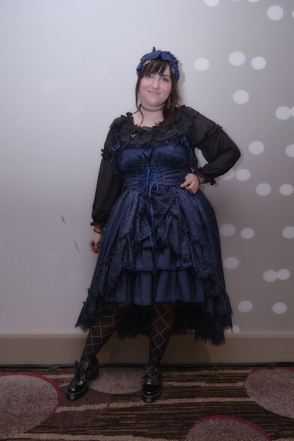 Gothic lolita wearing navy lace dress and black blouse.