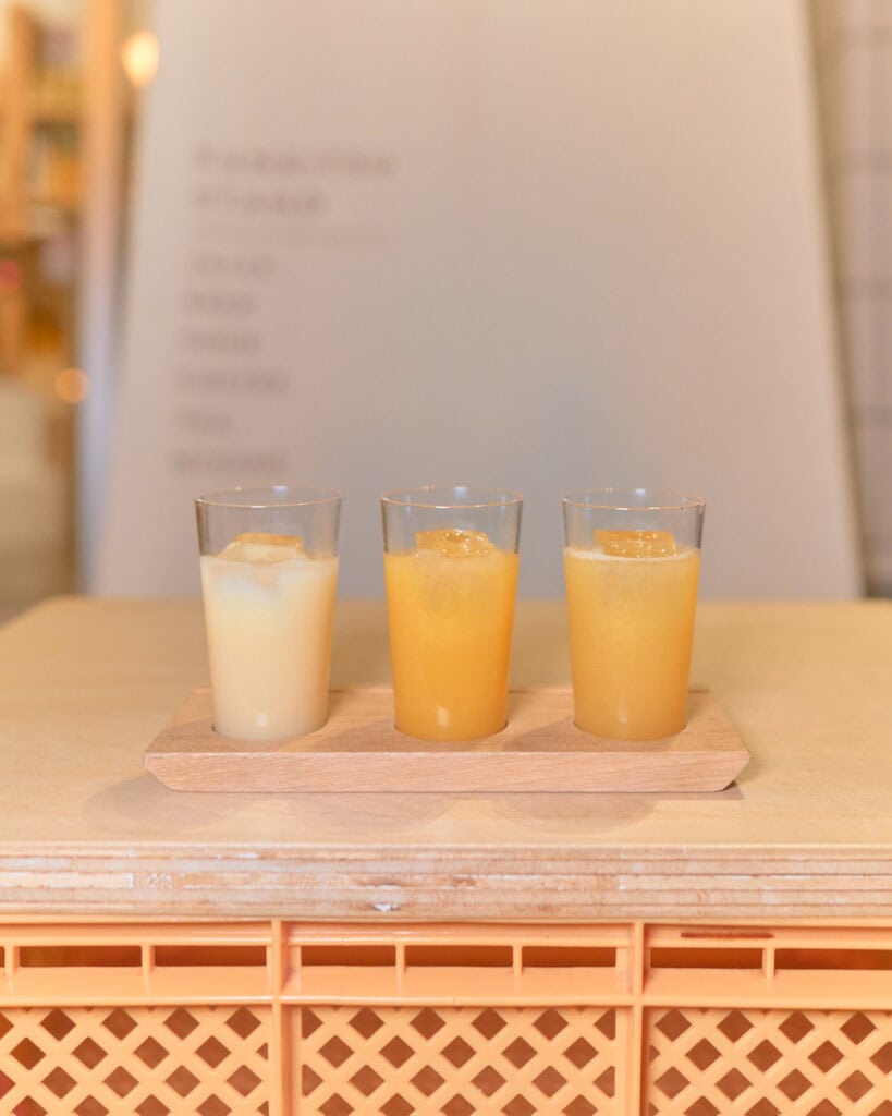 Close up of three orange juice flight at Kankitsu Stand Orange outside of Onomichi station