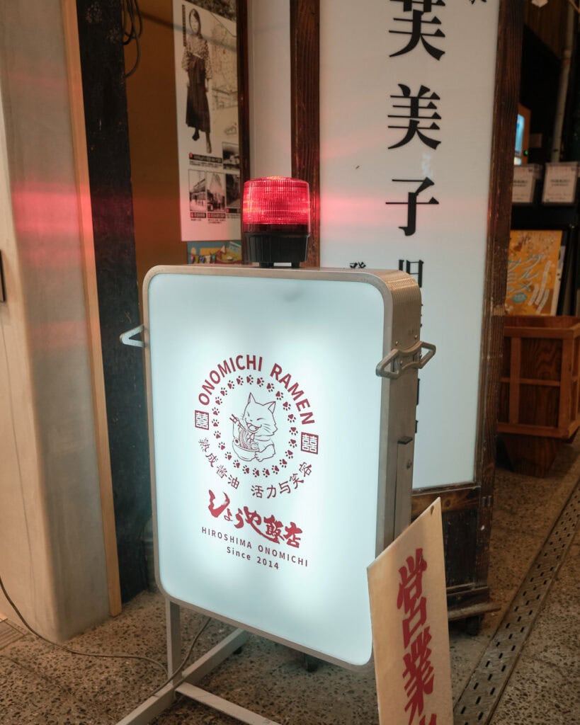 Onomichi Ramen shop sight with a cat eating ramen