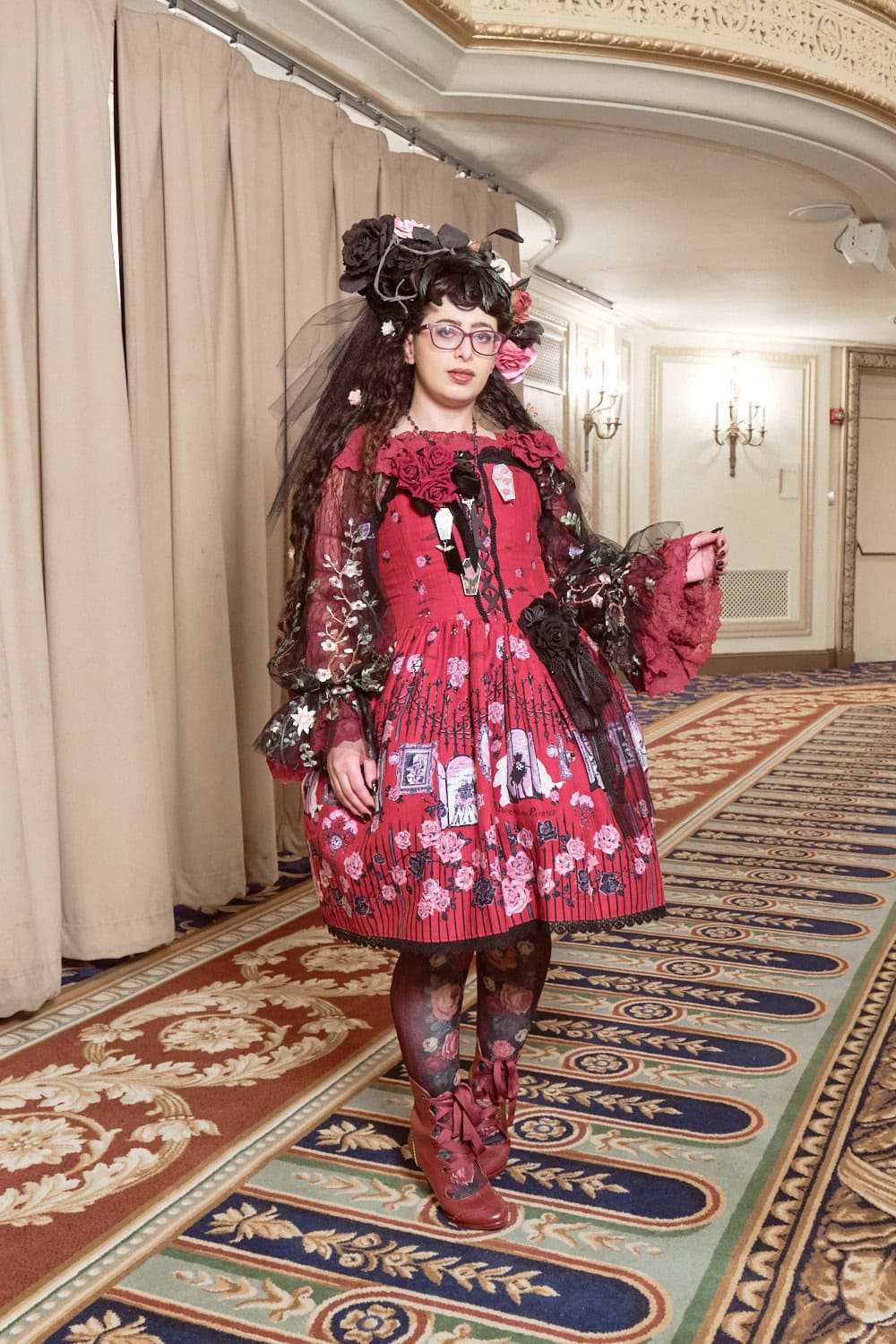 Gothic lolita wearing mostly red vampire print by Alice and the Pirates print dress accessorized with rose theme accessories.