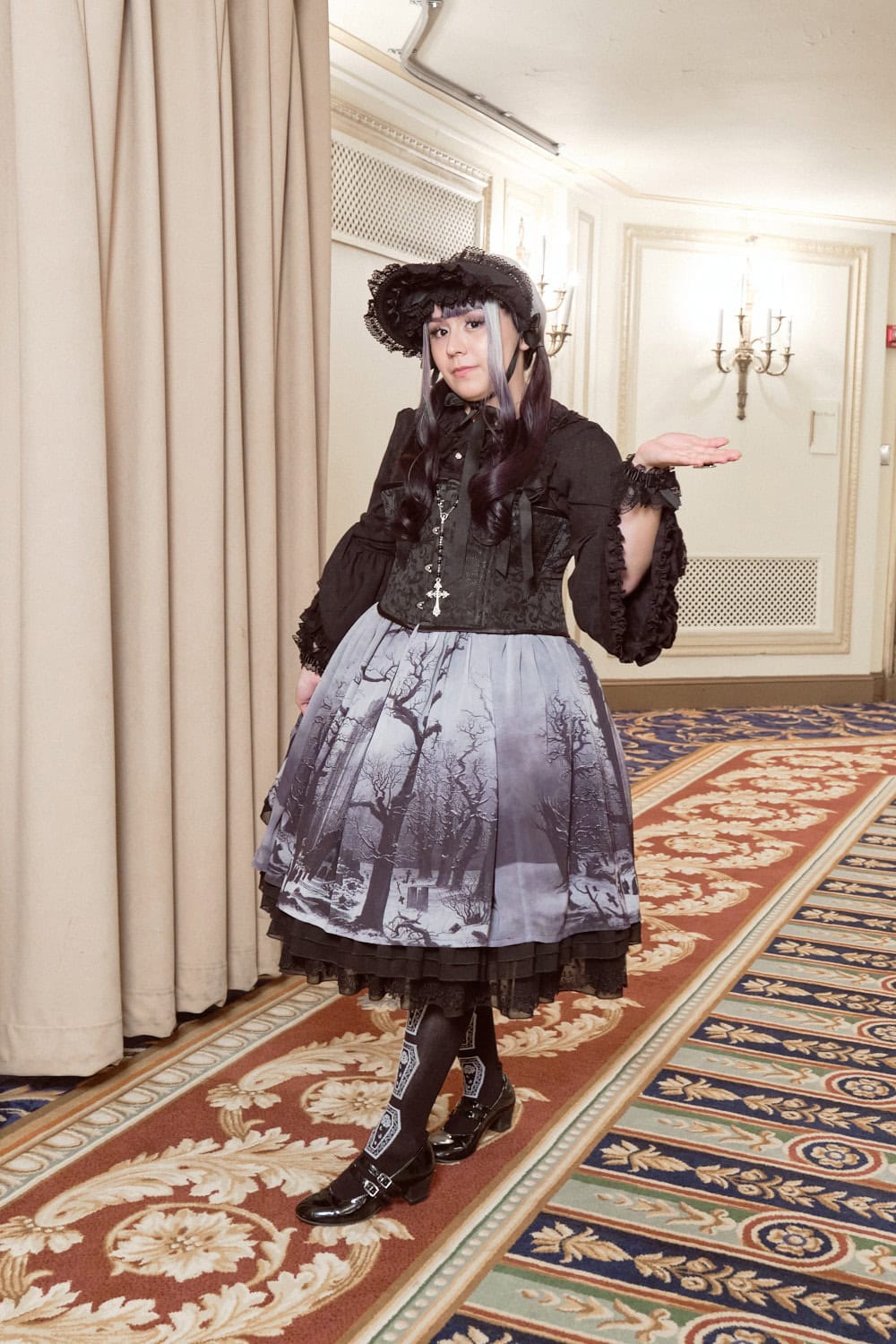 Gothic lolita wearing bonnet, corset, and print skirt with a winter forest image.