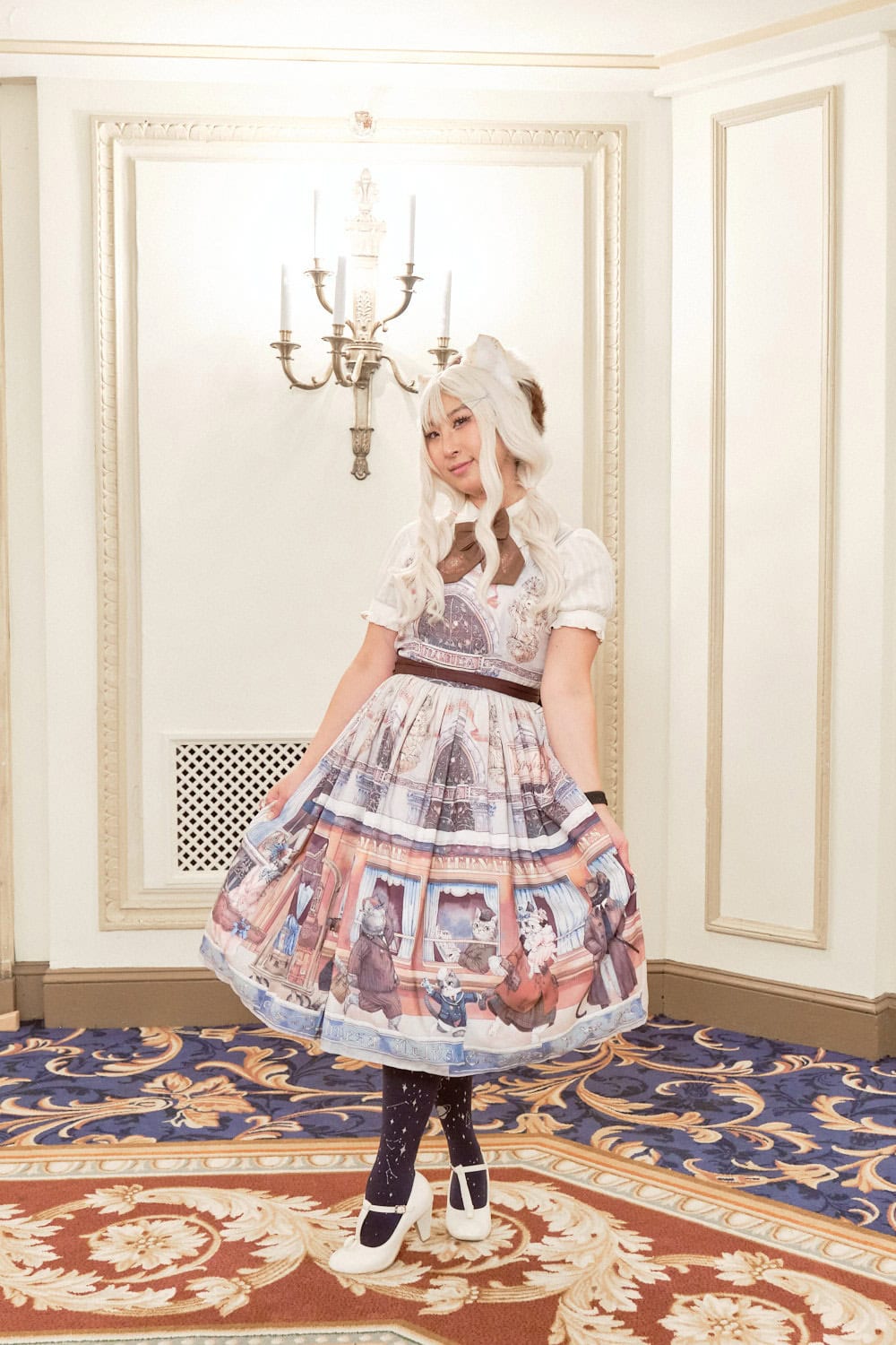 Classic lolita wearing cat ears and dress depicting cats walking on a street.