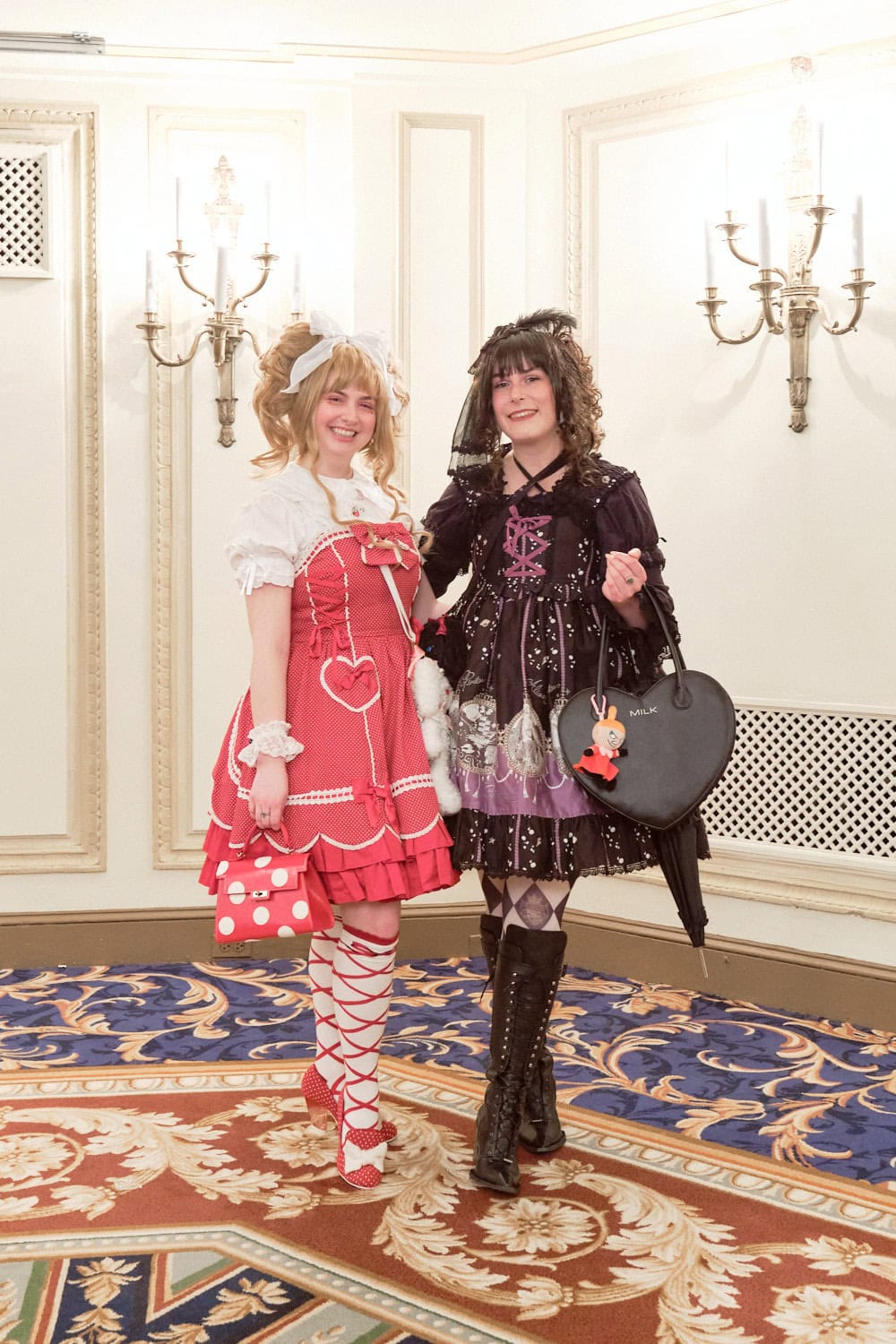 Two lolitas standing next to each other. One is wearing red and one is wearing black.