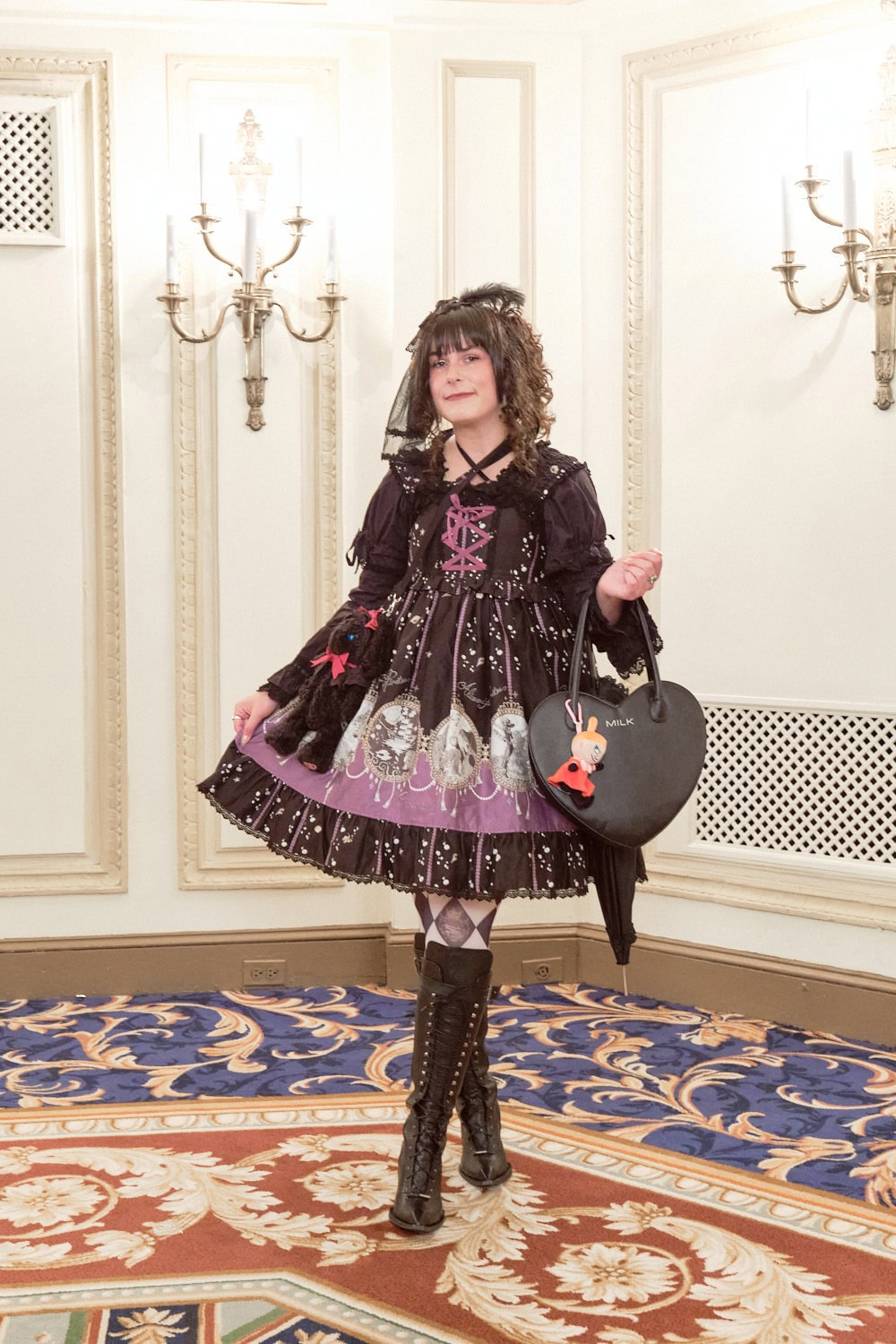 Gothic lolita wearing Alice and the Pirates nautical dress in black, black cat bag, knee high boots, and black heart shaped purse.