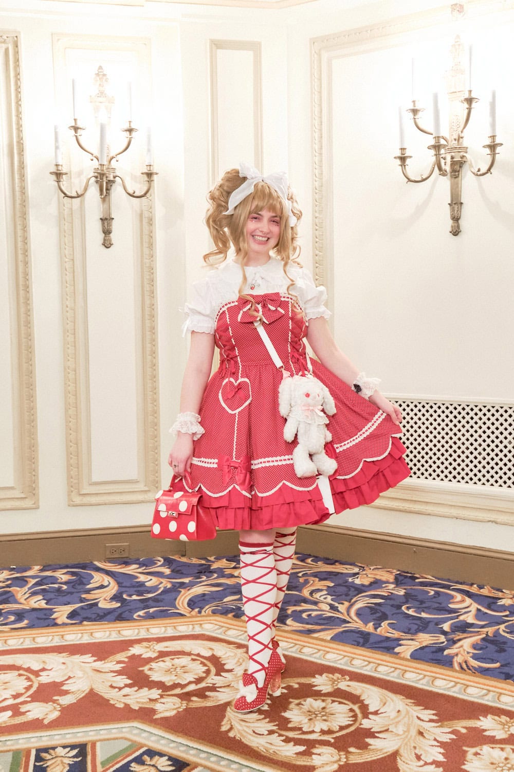Sweet lolita wearing solid red jumperskirt with white blouse and white usakumya crossbody bag.