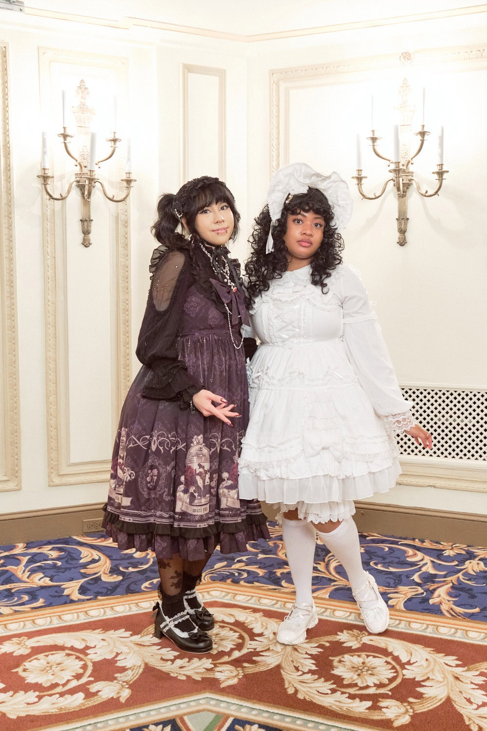 Two lolitas standing with each other. One is wearing black and one is wearing white.