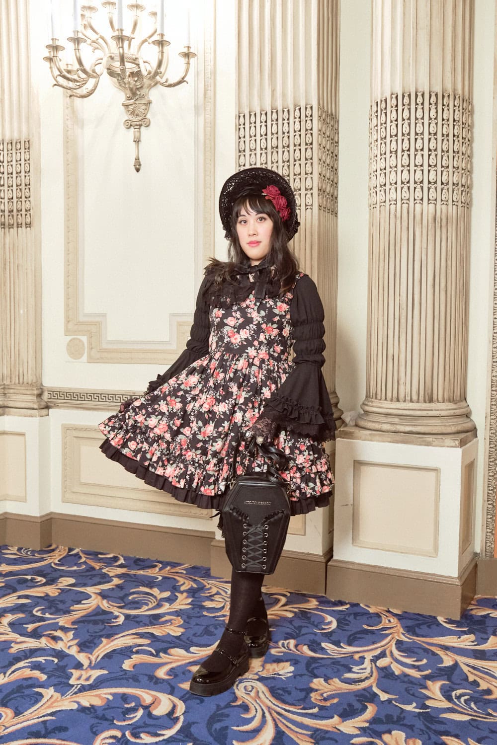 Classic lolita wearing black floral print dress and holding coffin shaped purse.