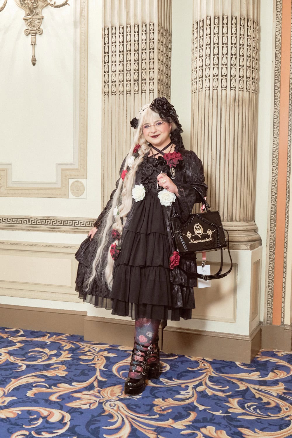 Gothic lolita wearing mostly black princess dress with red rose accents.