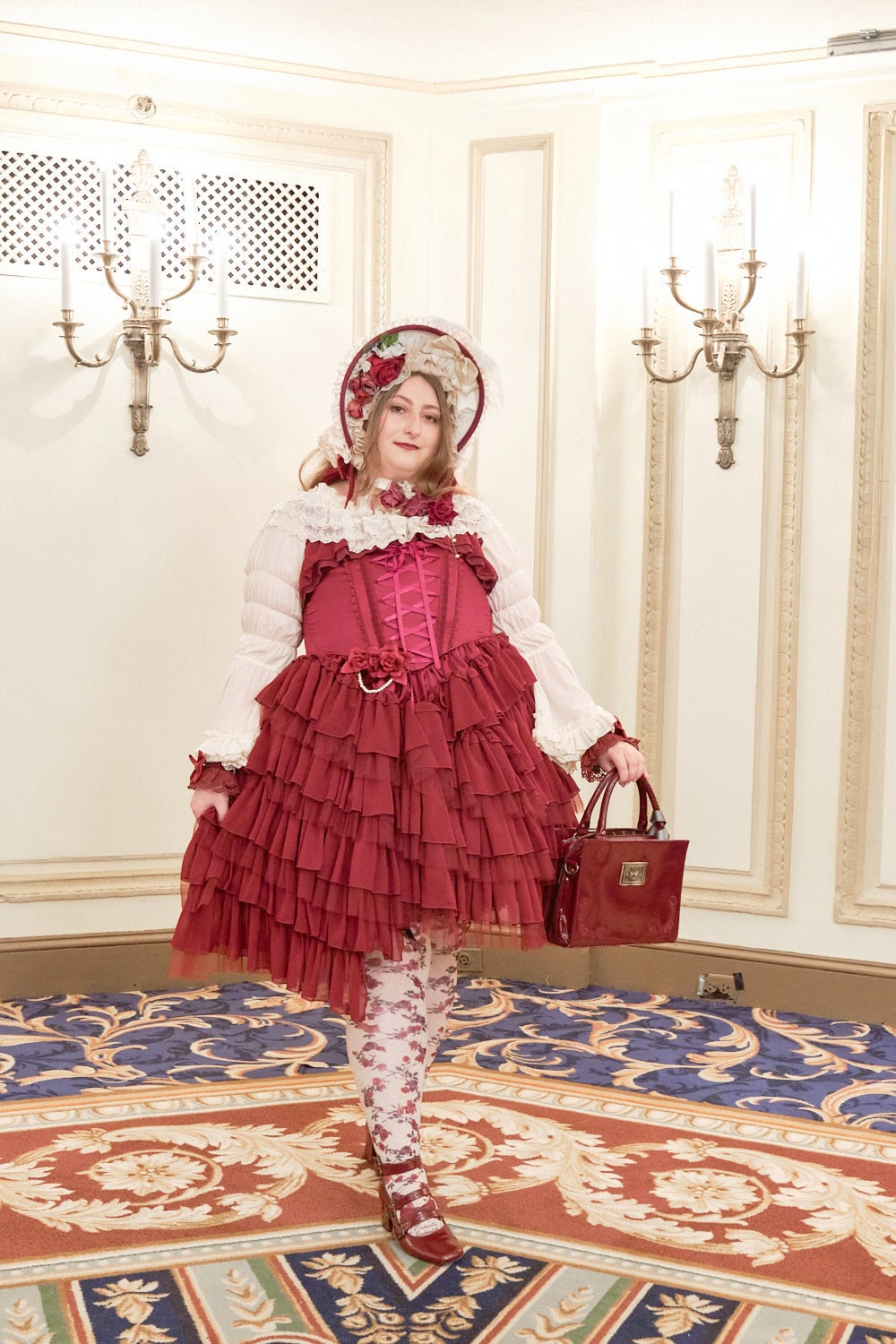 Classic lolita wearing red and cream outfit with bonnet and tulle tiered jumperskirt.