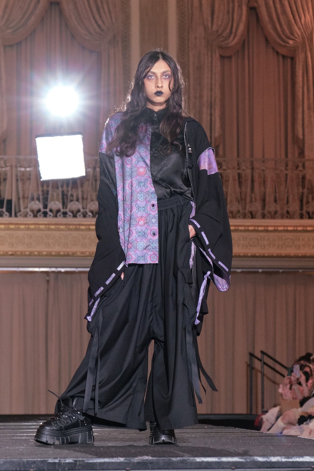 Model 17 wearing black and purple wa goth set by Axes-X. The set has a kimono sleeve jacket, button up shirt, and hakama style pants.