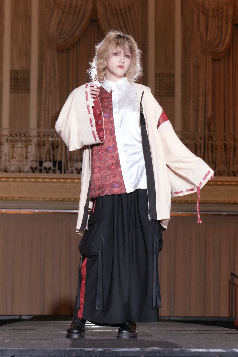 Model 18 wearing the same set as model 17, but in a different color by Axes-X. Their kimono style jacket is cream and red, blouse is white and red, and the hakama pants are black and red.
