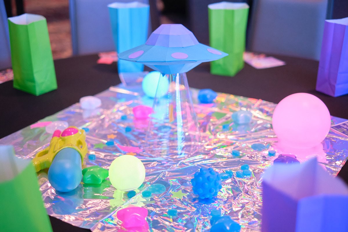 Paper UFO and colorful balls on table as centerpiece.