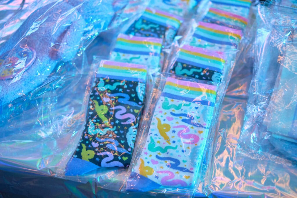 Stacks of pastel worm on a string themed socks on table.