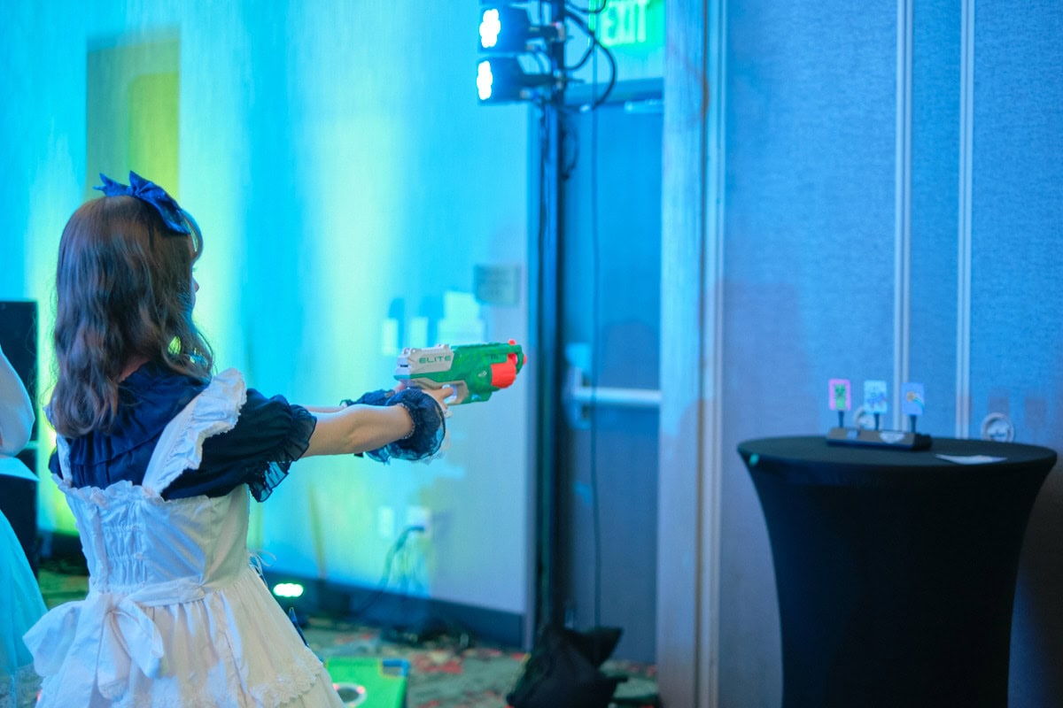 Attendee aiming nerf gun at alien targets.