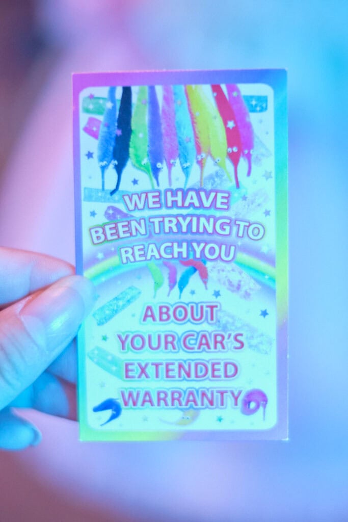 A rainbow business card with worms on a string "We have been trying to reach you about your car's extended warranty,"