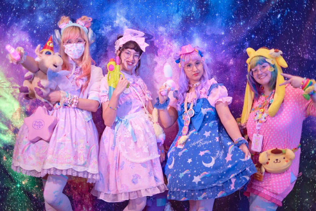 Four friends group photo in front of galaxy backdrop.
