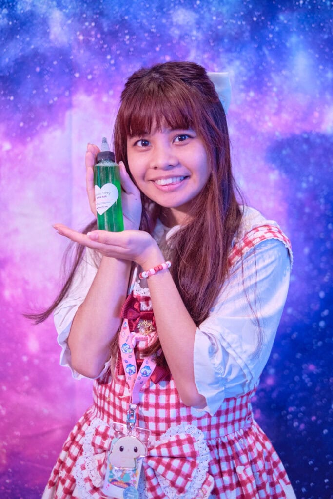 Raffle prize winner holding bottle of scented green liquid.