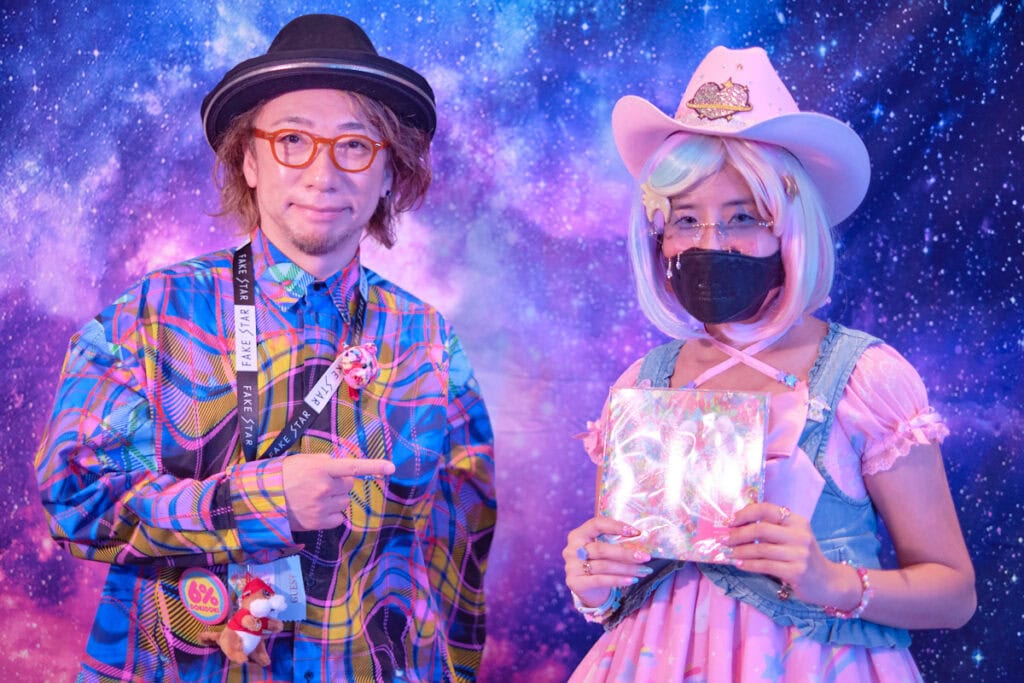 Designer Sebastian Masuda standing with raffle prize winner 1.