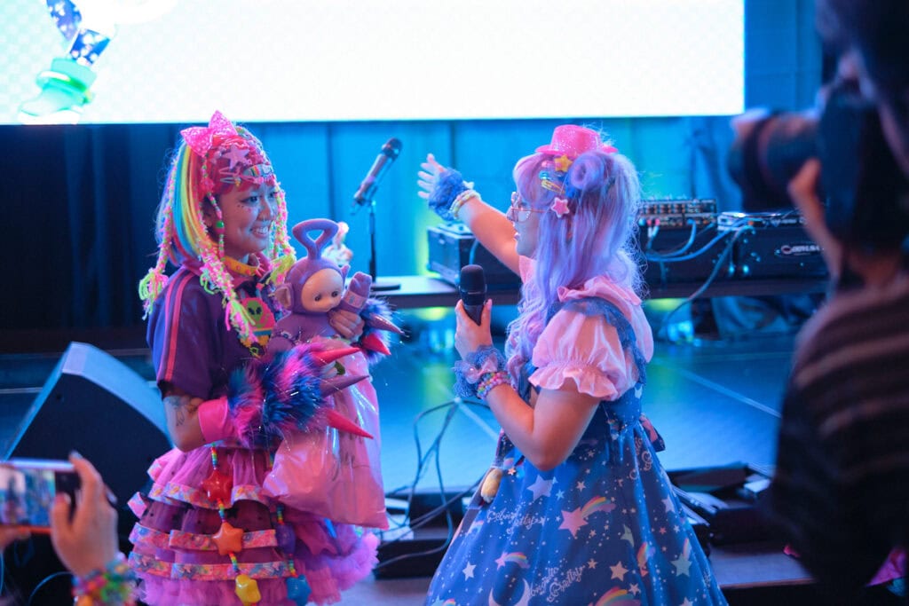Two pastel wearing people talking to each other.