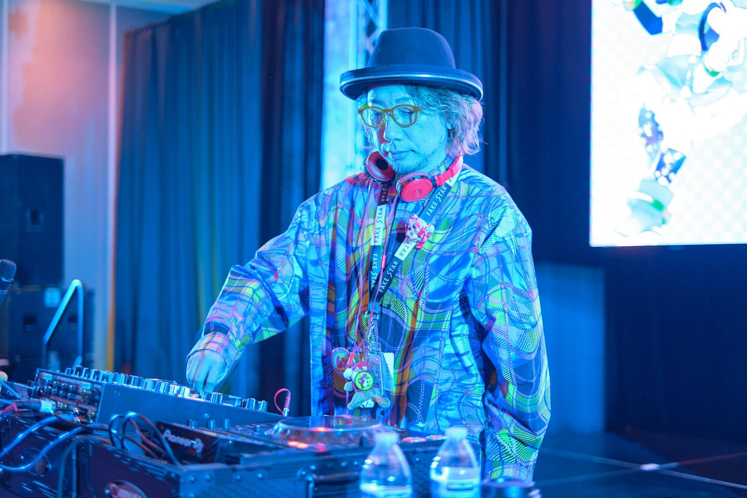 Sebastian Masuda fiddling with knobs on DJ equipment photographed from front,
