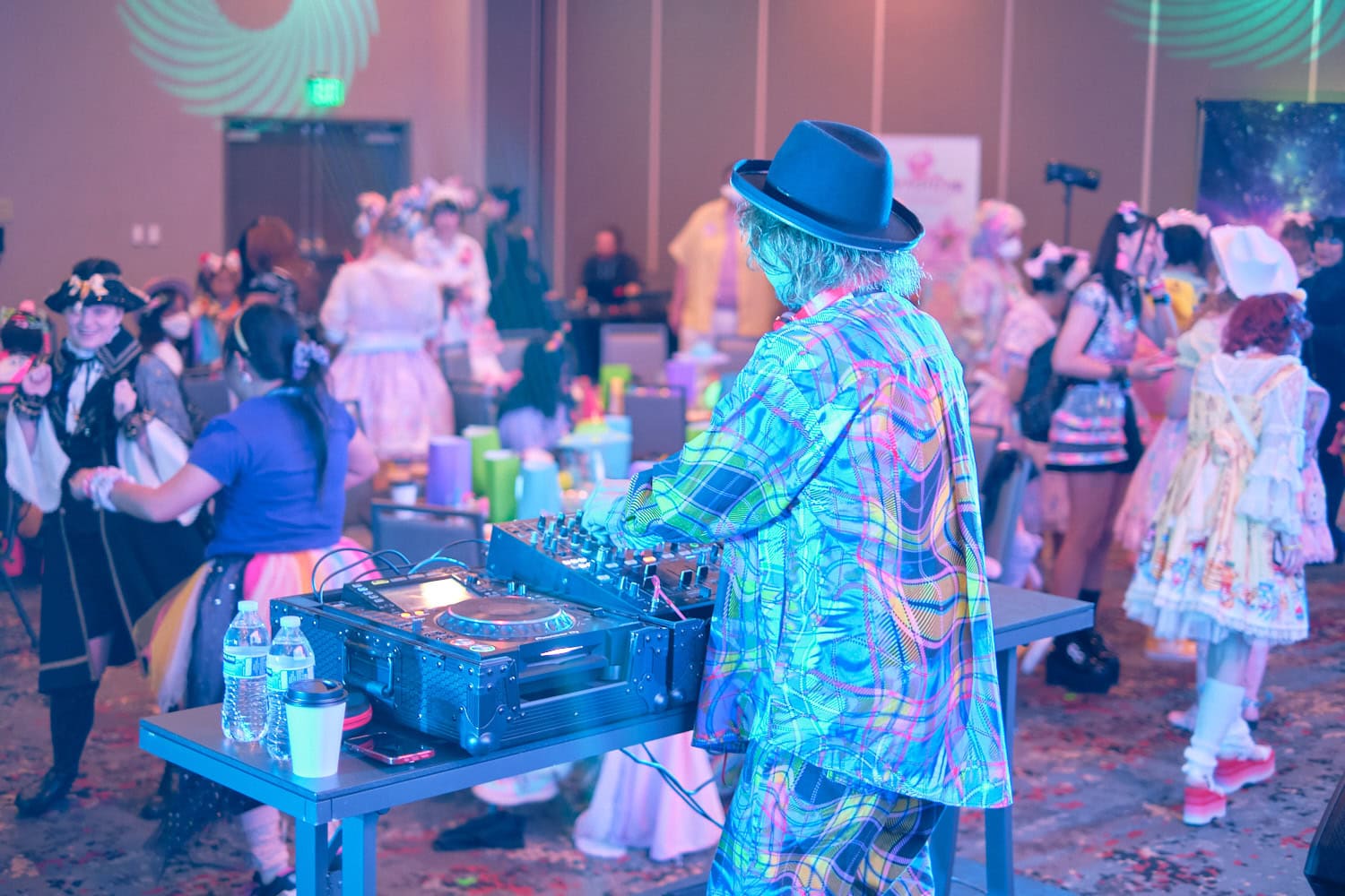 Sebastian Masuda DJing event photographed from behind as crowd dances and mingles.