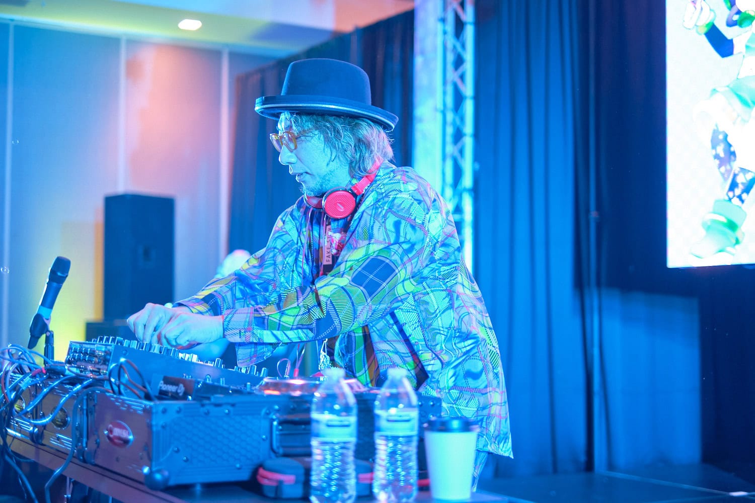 Sebastian Masuda fiddling with knobs on DJ equipment photographed from side.