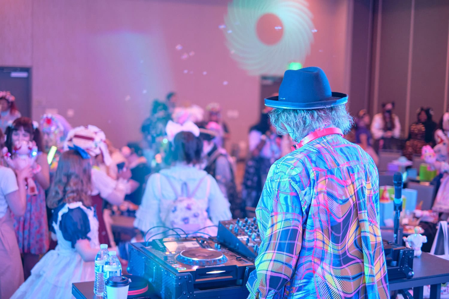 Sebastian Masuda fiddling with knobs on DJ equipment photographed from back,