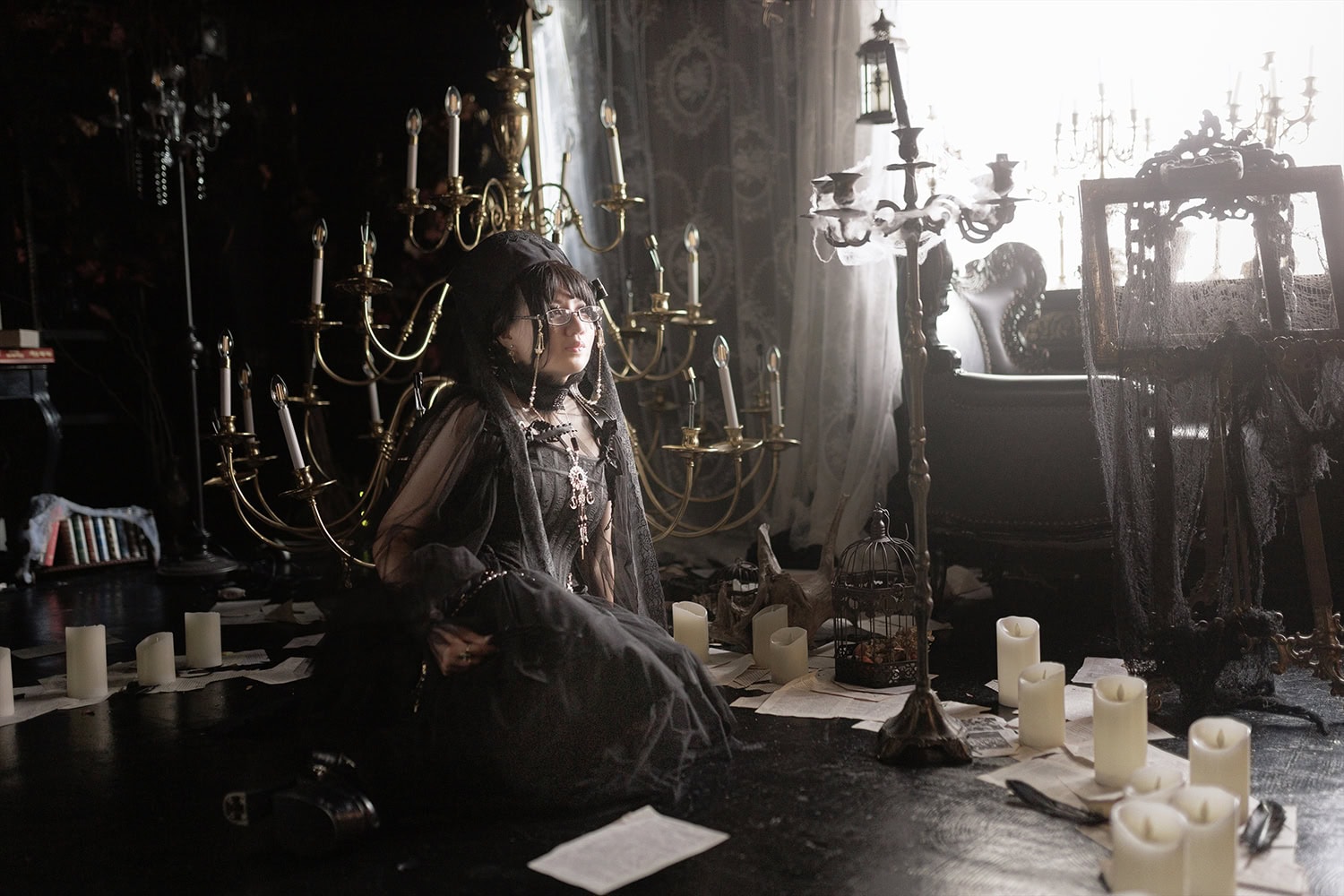 Stephano sitting on floor in front of giant chandelier and antiques.