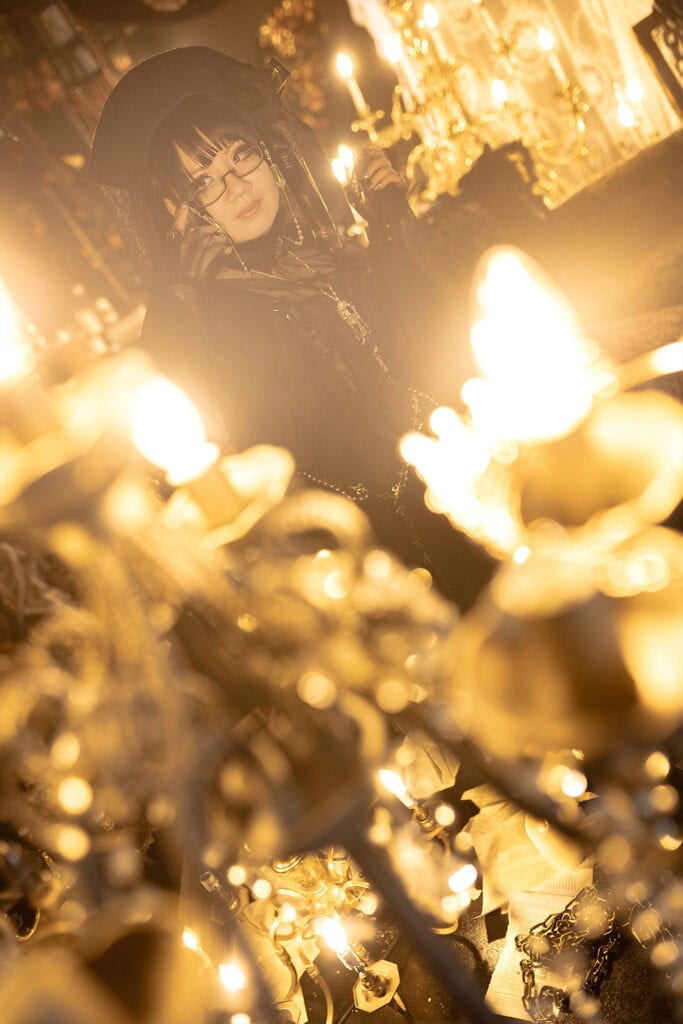 Chandelier blurred in foreground with Stephano in focus in the background.