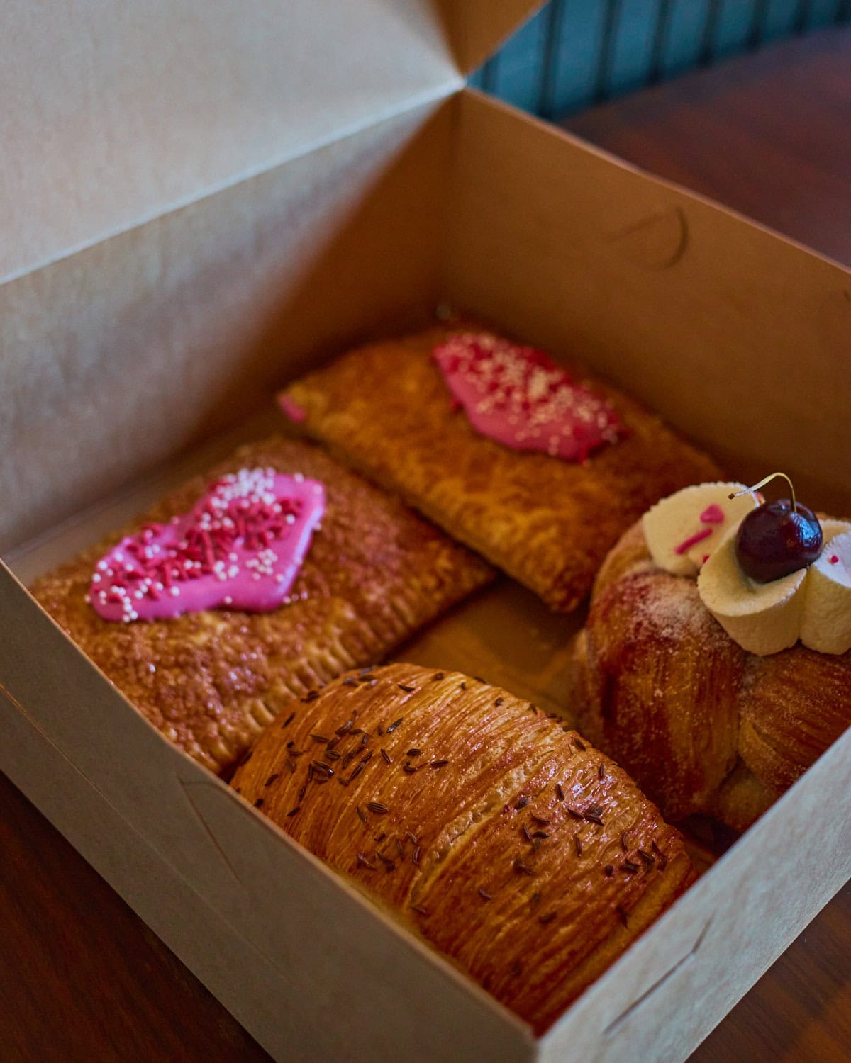 Bandit Patisserie pastry box with cherry basket, pastrami croissant, and strawberry pop tart