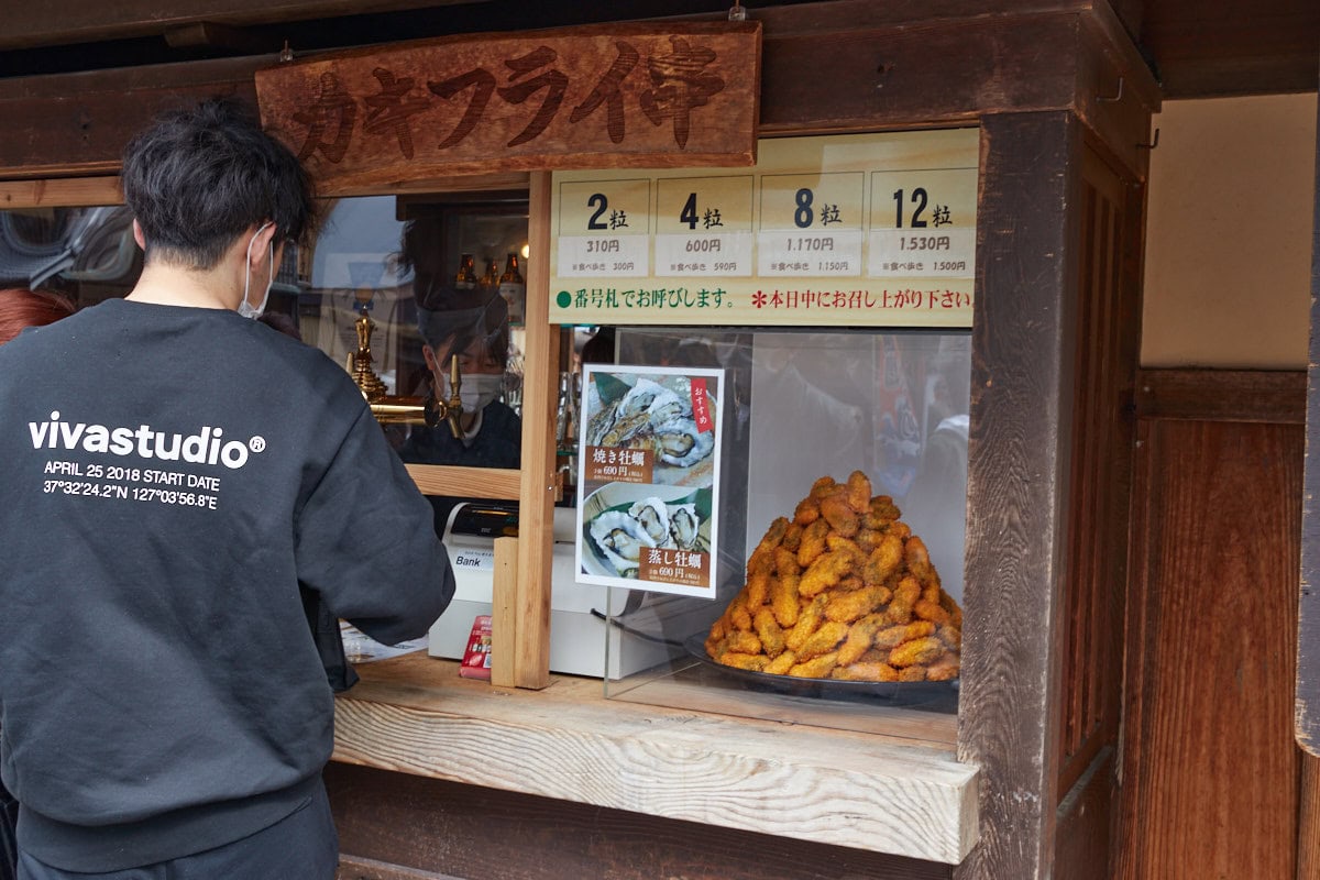 A street food store front with a pile of fried oysters on display