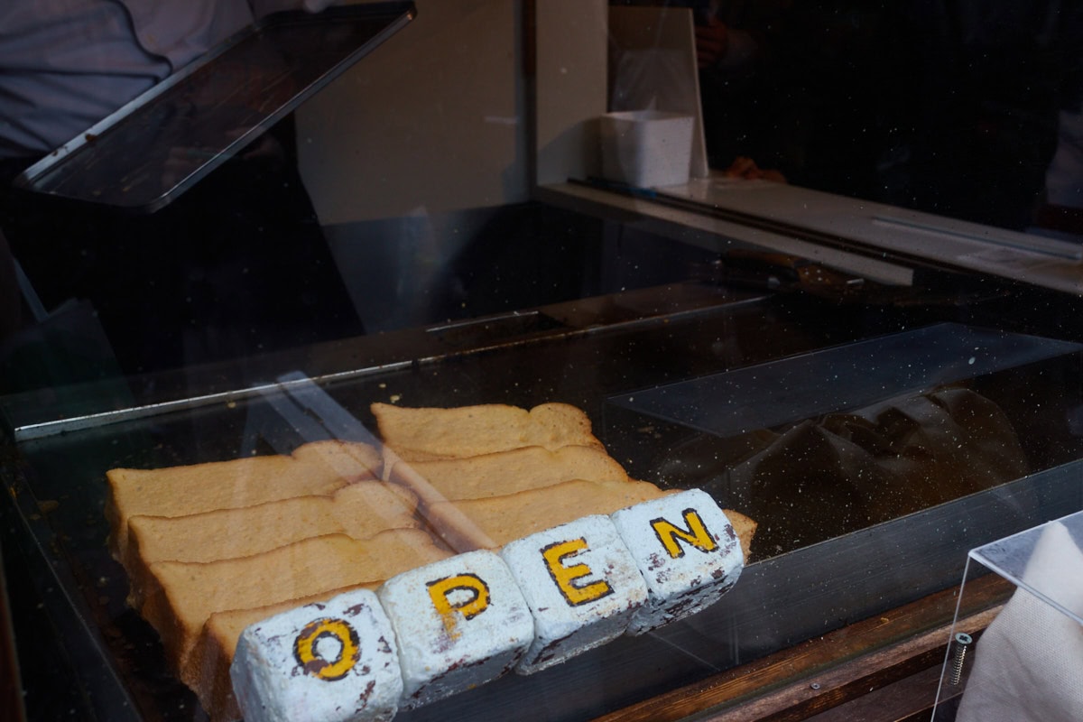 A flat top grill with pudding toast being layed out to be cooked