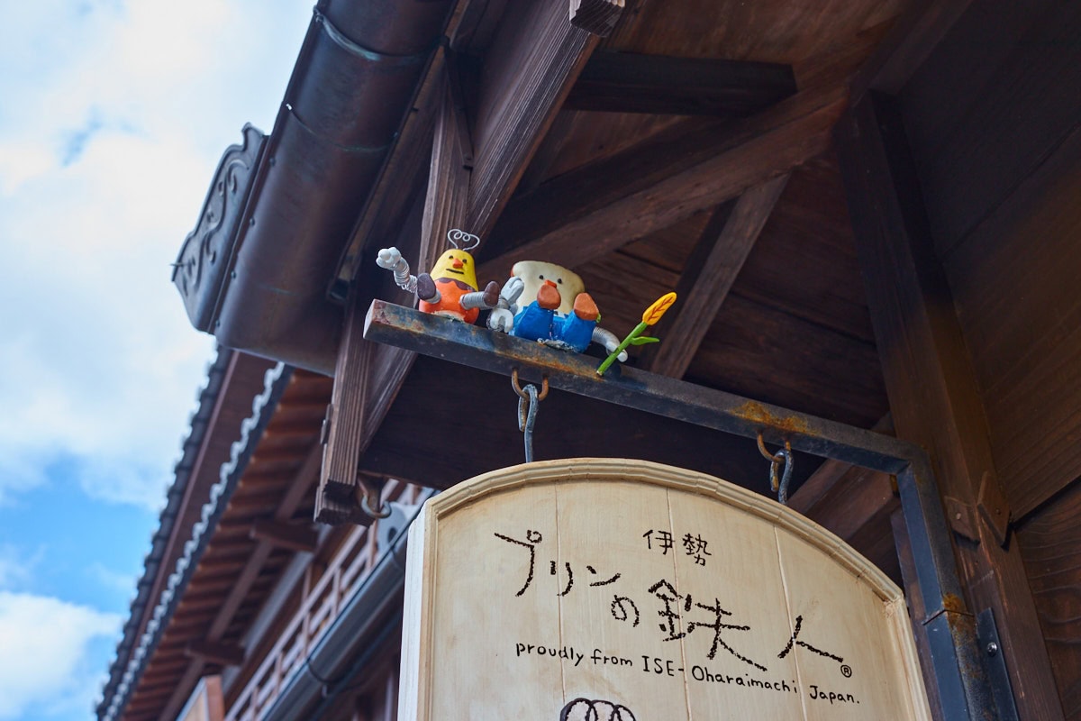Pudding and pudding toast characters sitting on a hanging sign