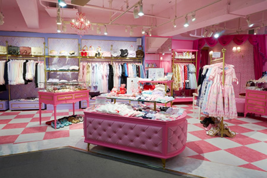 Angelic Pretty's Harajuku storefront inside of LaForet department store. Colorful pastel dresses hang inside a cute pink, white, and gold interior.