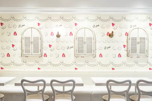 Q-pot Cafe's whip cream and strawberry wallpaper room with dining booths and chairs.
