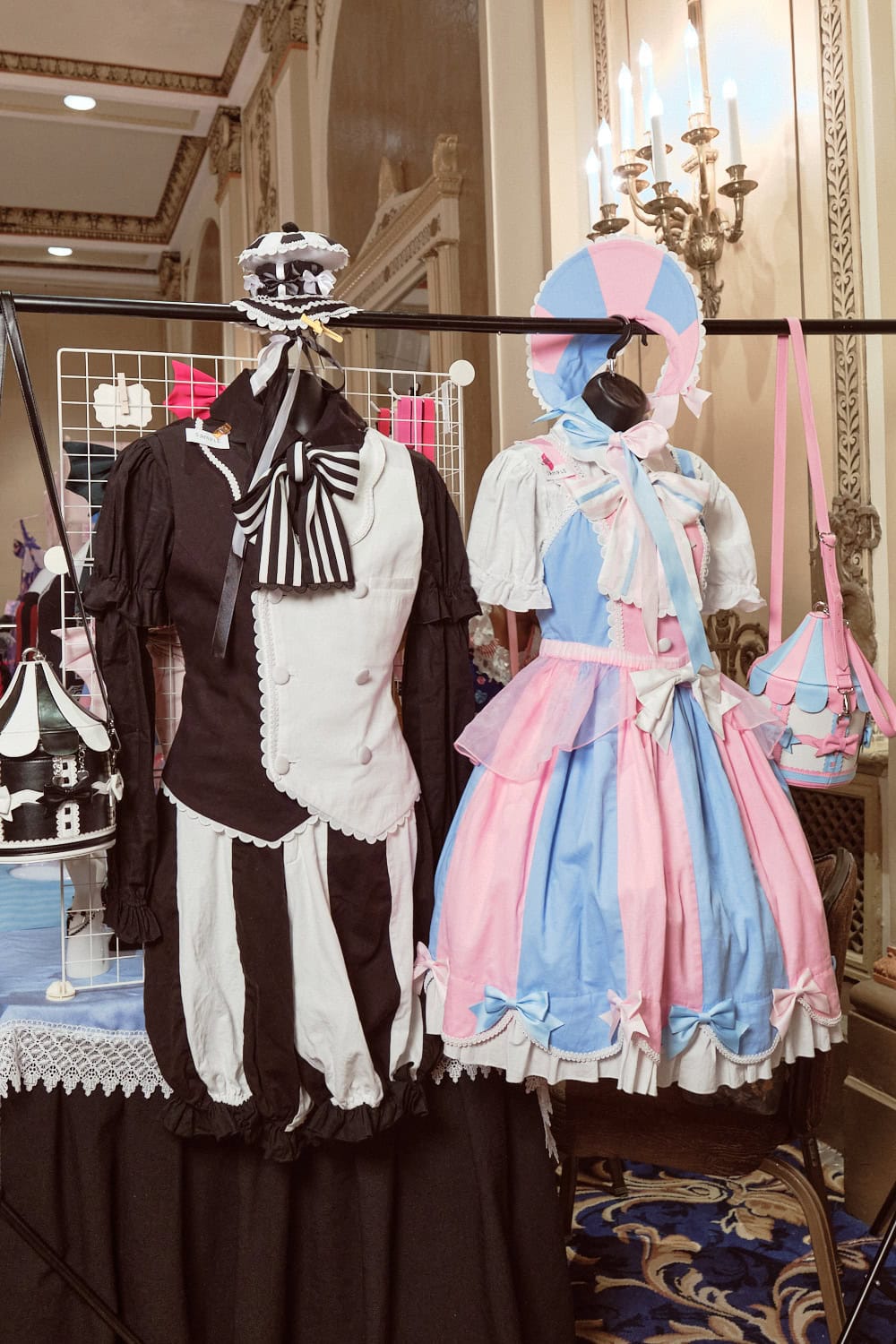 Two stripe ensembles by Dandy Puppeteer. The left is a black and white strip vest, blouse, and shorts ouji style combo. The right is a pink and sax stripe light blue and pink bonnet, jumperskirt, and carousel purse sweet lolita combo.