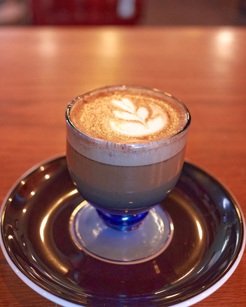 smoked rosemary cortado in a blue goblet glass
